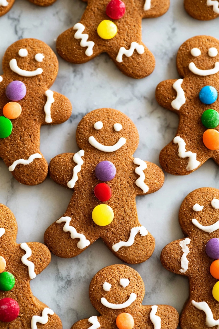 A close-up image shows a brown gingerbread cookie shaped like a person being held by two small hands. The gingerbread figure has white icing eyes made of small dots, a curved white icing smile, and white icing zigzag designs on the edges of the arms and legs. Three round candies in blue, red, and yellow are placed vertically in the center of the cookie's body with white icing borders. The background has several similar gingerbread cookies blurred out, all decorated similarly, set on a white marbled surface. photo taken with an iphone --ar 2:3 --v 7