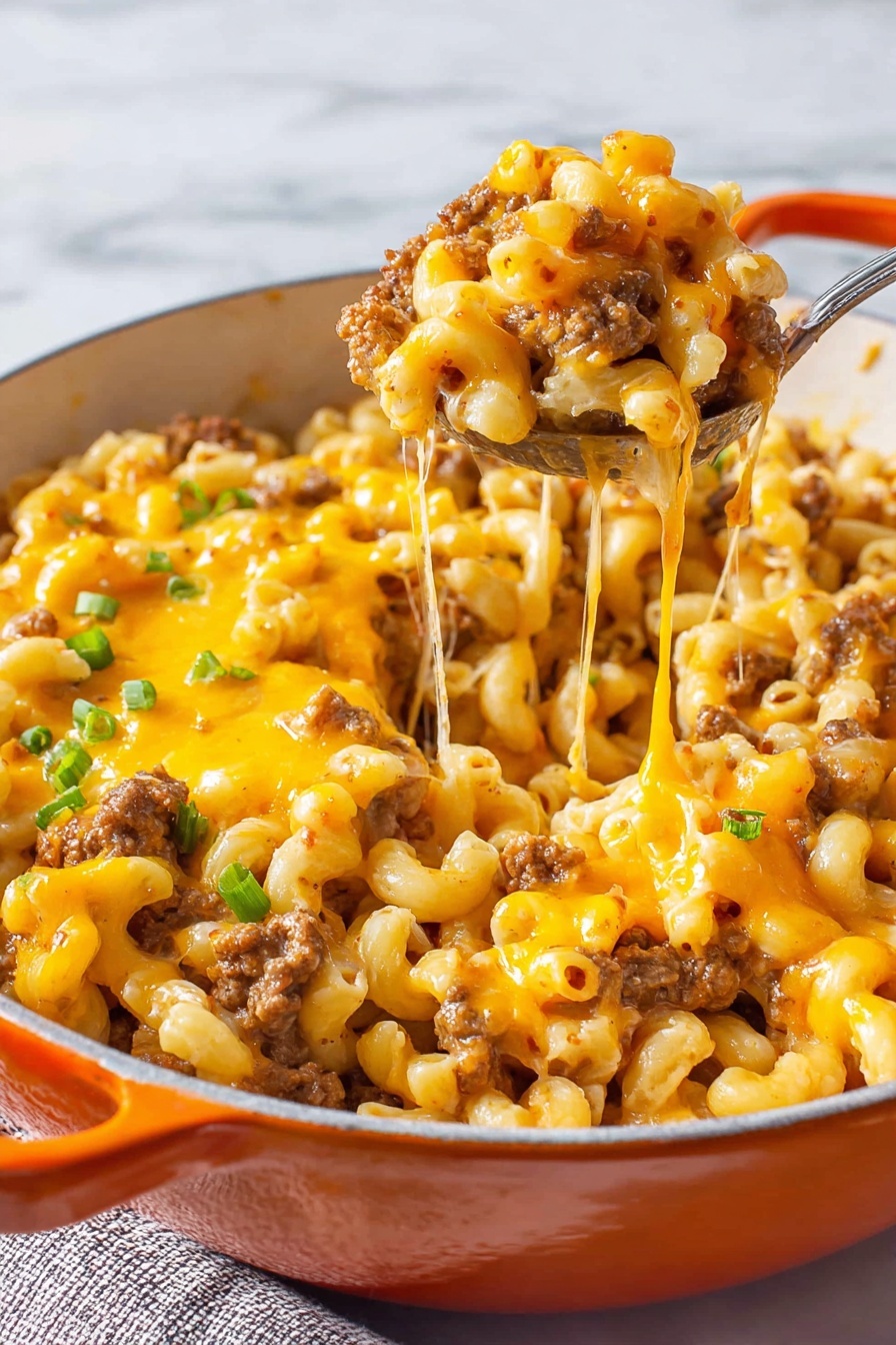 The dish is a baked macaroni and cheese with ground meat served in a white pot with an orange handle. The top layer is covered with melted yellow cheese that looks stringy and slightly browned in spots. Underneath the melted cheese, there are visible browned ground meat pieces mixed evenly throughout the curly pasta, which is pale yellow. Small chopped green onions are sprinkled on top, adding a touch of green. A silver spoon lifts a serving showing the cheese stretching from the pot. The background is a white marbled surface. photo taken with an iphone --ar 2:3 --v 7