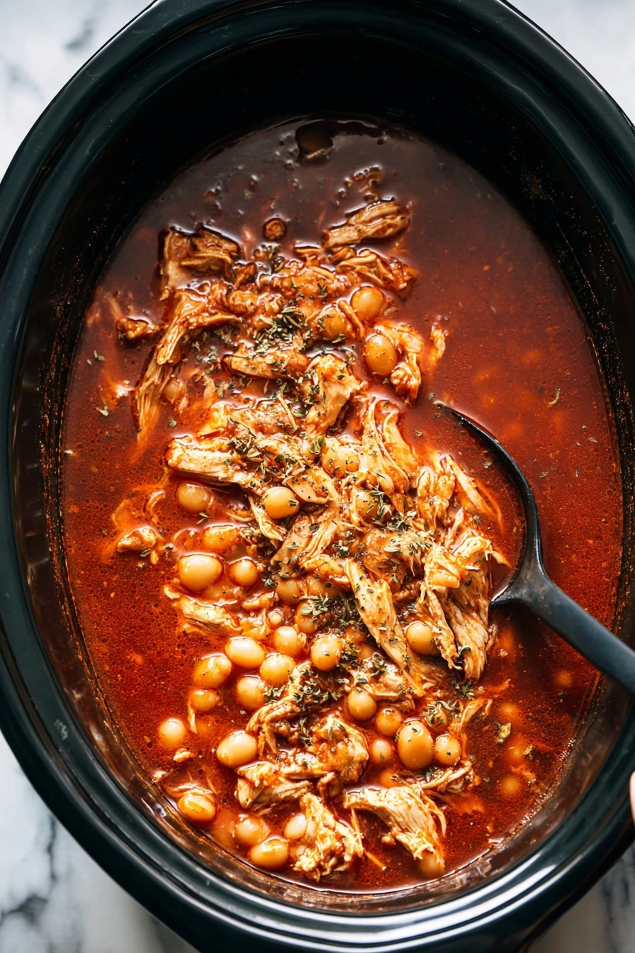 A white bowl filled with a rich red soup with chunks of shredded chicken and white hominy spread evenly throughout. On the left side, there is a layer of thinly sliced cabbage and round radish slices arranged neatly, with small green cilantro leaves sprinkled on top. A bright green lime wedge rests on the right edge of the bowl, partially submerged in the soup. A black spoon is placed inside the bowl, leaning on the right side. The bowl sits on a white marbled surface with lime wedges and cilantro leaves scattered around, alongside a small white plate holding more radish slices and a mustard yellow textured cloth near the bottom right corner. Photo taken with an iphone --ar 2:3 --v 7