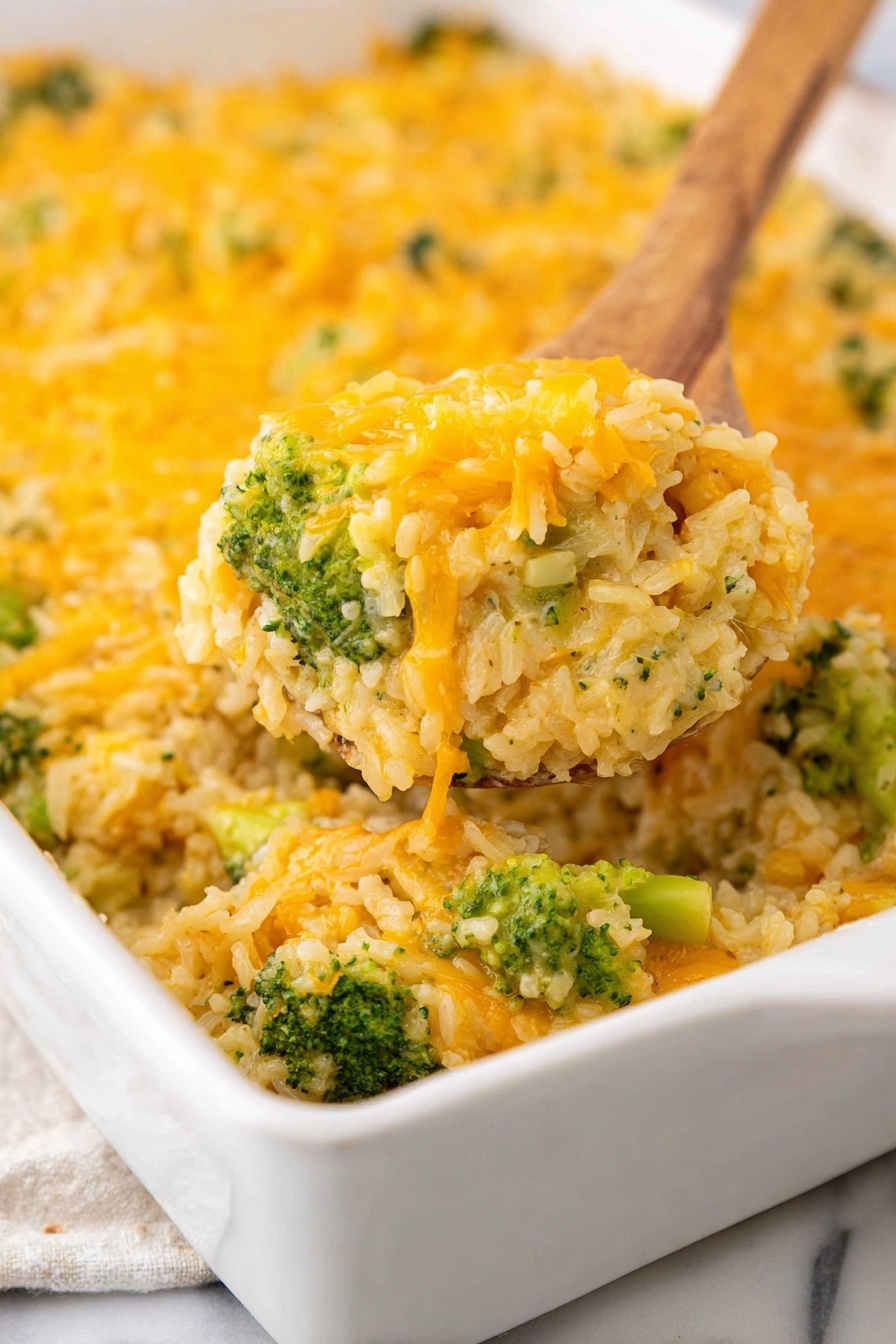 The image shows a close-up of a white rectangular baking dish filled with a broccoli and cheese casserole. The dish has three visible layers: the bottom layer is a creamy mixture with small pieces of broccoli, light green and beige in color; the middle layer consists of chunks of bright green broccoli; the top layer is covered with melted shredded orange cheese, giving a textured and slightly glossy look. A wooden spoon is lifting a scoop of the casserole from the dish, showing the mixed layers clearly. The dish sits on a white marbled surface. photo taken with an iphone --ar 2:3 --v 7
