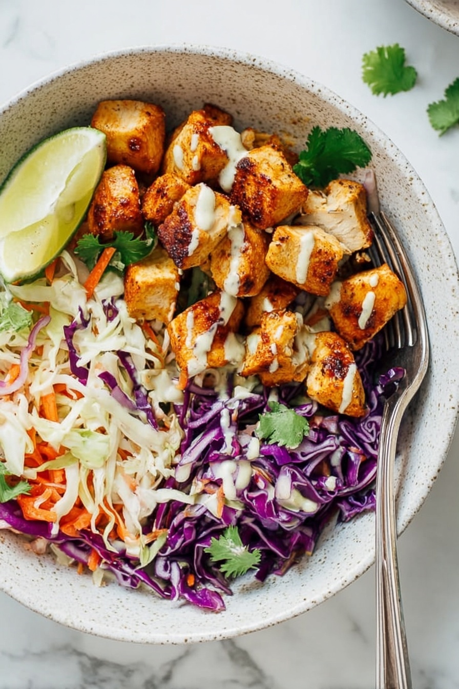 A white speckled bowl is filled with two main layers: on one side, there are bite-sized pieces of golden brown seasoned chicken with a creamy light sauce drizzled on top, and on the other side, a colorful mix of shredded purple and white cabbage with thin orange carrot strips, garnished with fresh green cilantro leaves and a lime wedge placed near the chicken. Surrounding the bowl is a glass of light creamy sauce, fresh cilantro sprigs, and lime wedges on a white marbled surface with a few drops of sauce scattered around. Photo taken with an iphone --ar 2:3 --v 7